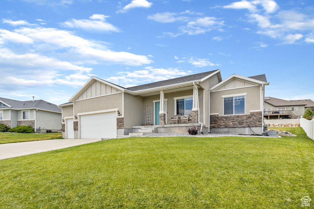 View of front of property featuring a garage and a front yard