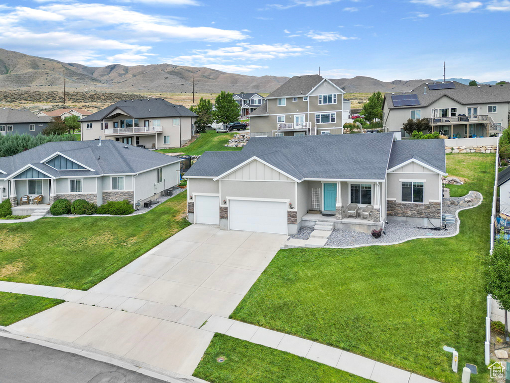 View of front of home featuring a mountain view, a garage, and a front yard