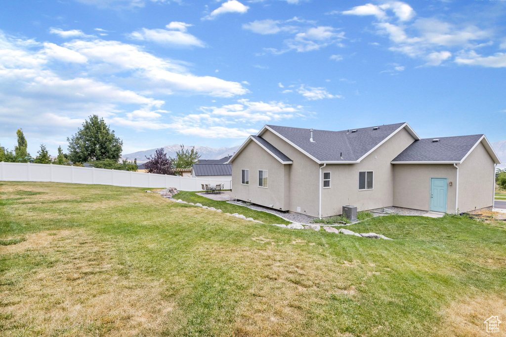 Rear view of house featuring a yard and cooling unit