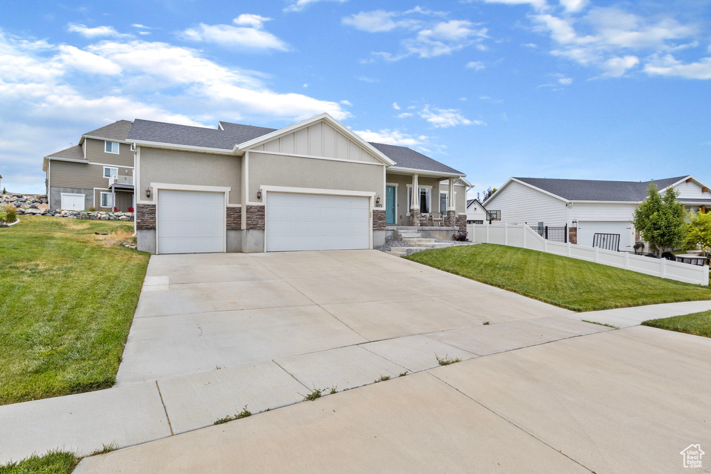 View of front facade featuring a garage and a front lawn