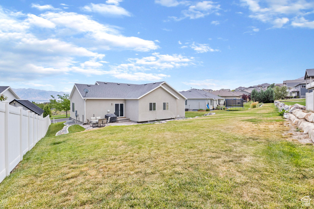 Rear view of property with a patio and a yard