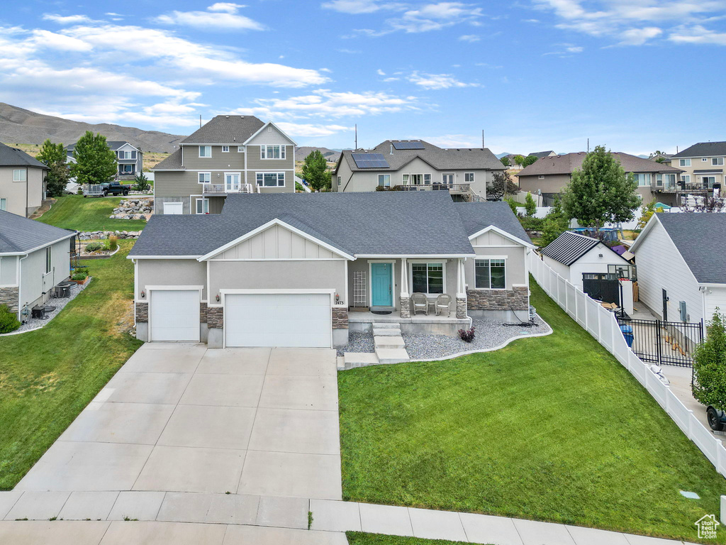 View of front of property featuring a garage and a front lawn