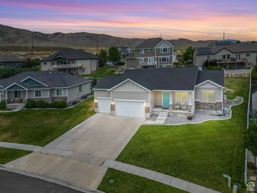 View of front of house featuring a garage, a yard, and a mountain view