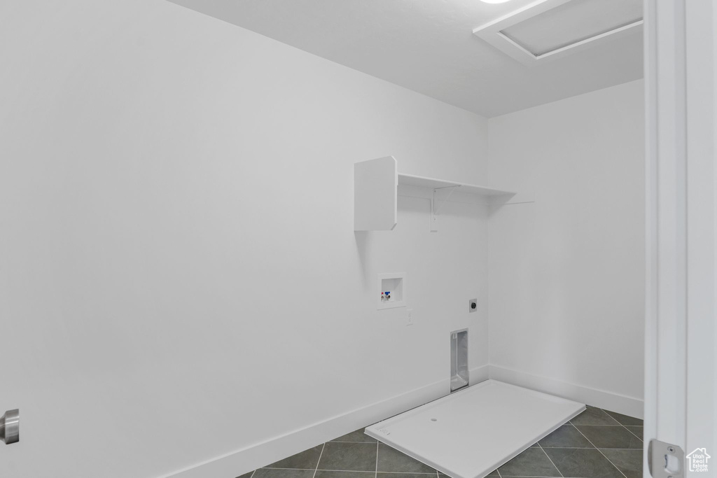 Clothes washing area featuring dark tile patterned floors, electric dryer hookup, and hookup for a washing machine