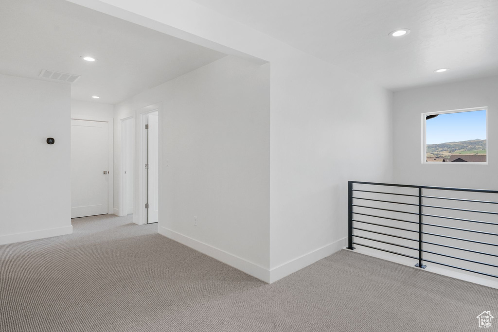 Hallway featuring light carpet