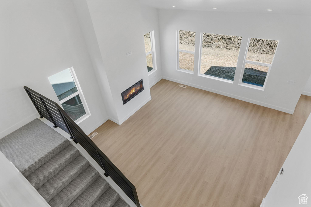 Living room featuring light hardwood / wood-style floors and high vaulted ceiling