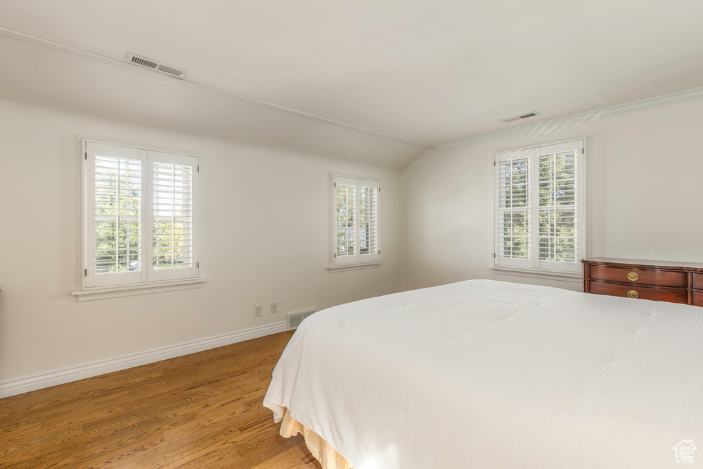 Bedroom with light hardwood / wood-style flooring and vaulted ceiling