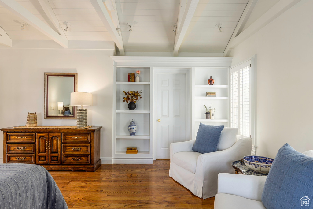 Bedroom featuring lofted ceiling with beams and dark hardwood / wood-style floors