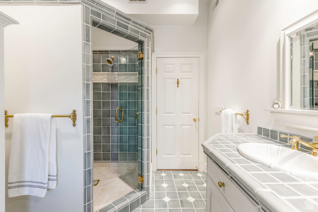 Bathroom featuring tile patterned flooring, an enclosed shower, and vanity