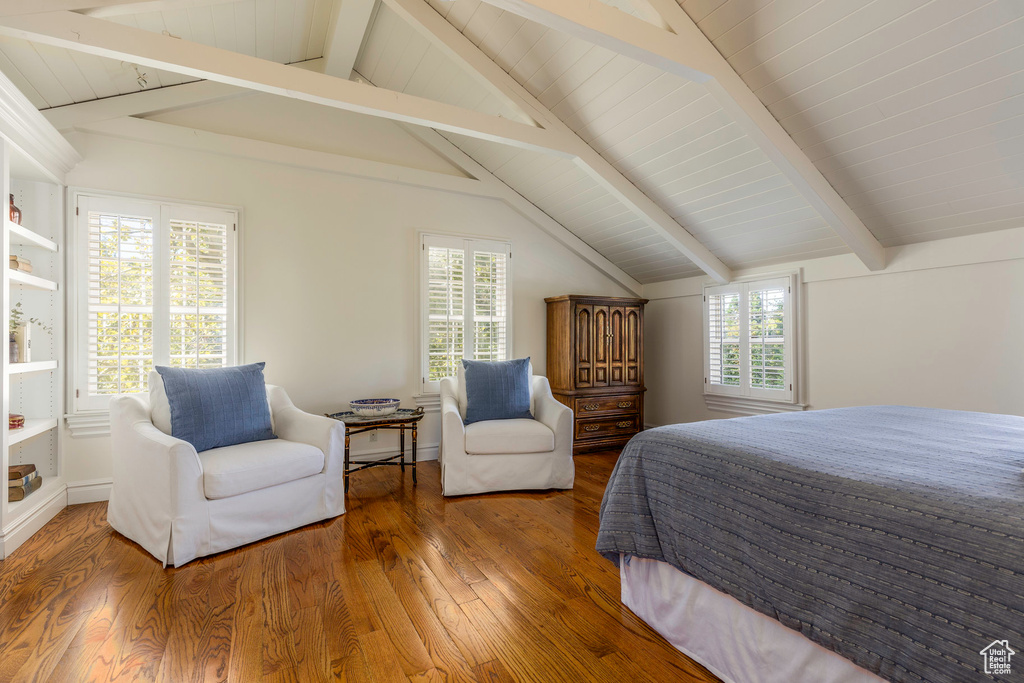 Bedroom featuring vaulted ceiling with beams, wood-type flooring, and multiple windows