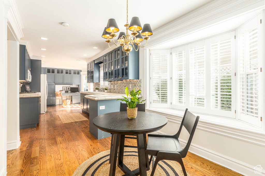 Dining room featuring a notable chandelier, crown molding, and hardwood / wood-style floors