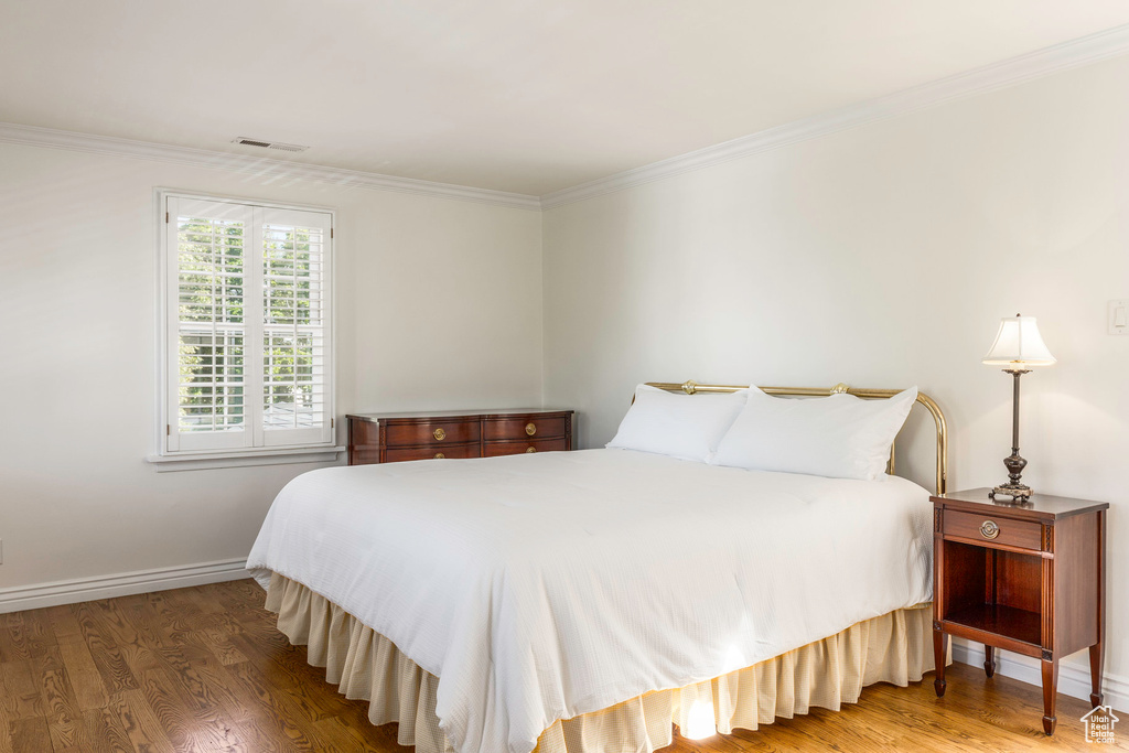 Bedroom with crown molding and light wood-type flooring