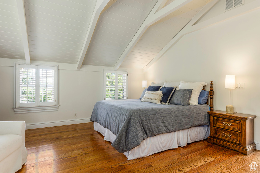 Bedroom with hardwood / wood-style flooring and lofted ceiling with beams