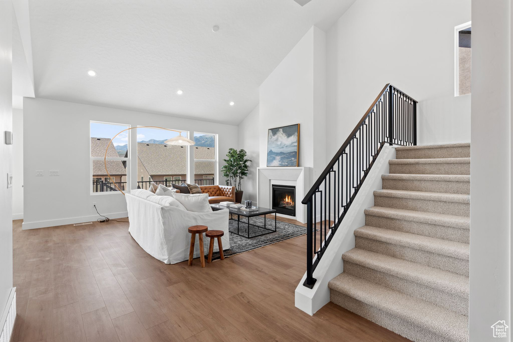 Living room featuring light wood-type flooring and high vaulted ceiling