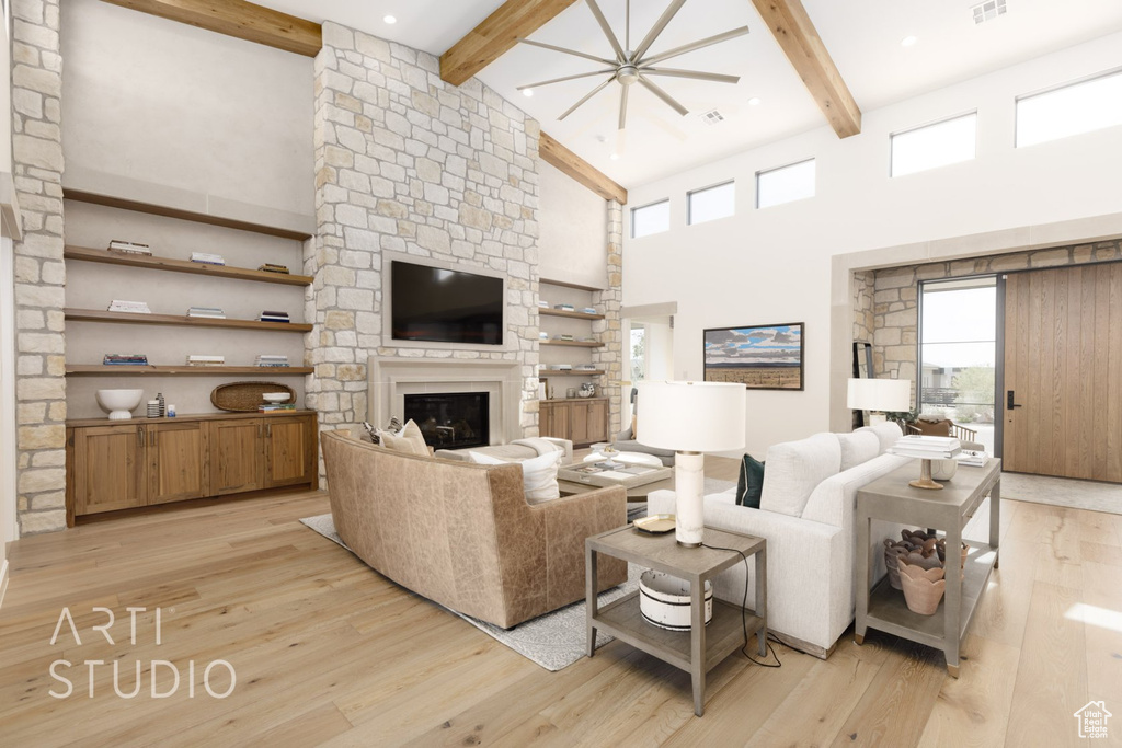 Living room featuring beam ceiling, high vaulted ceiling, a fireplace, and light wood-type flooring