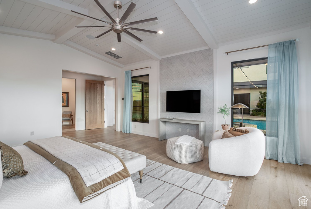 Bedroom featuring vaulted ceiling with beams, multiple windows, ceiling fan, and light hardwood / wood-style floors