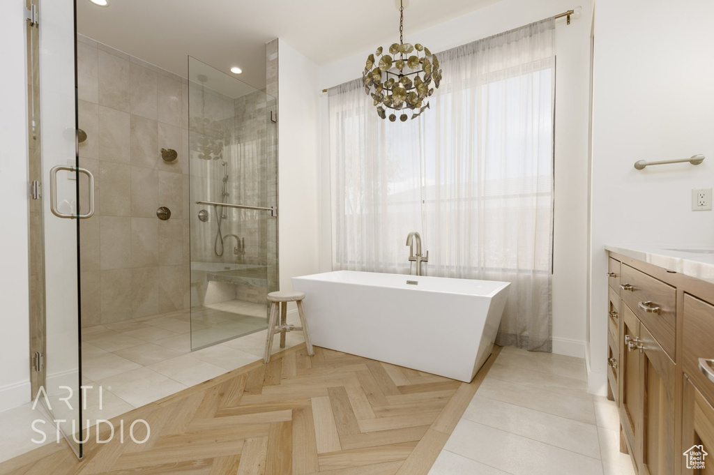 Bathroom featuring parquet floors, plus walk in shower, vanity, and a chandelier