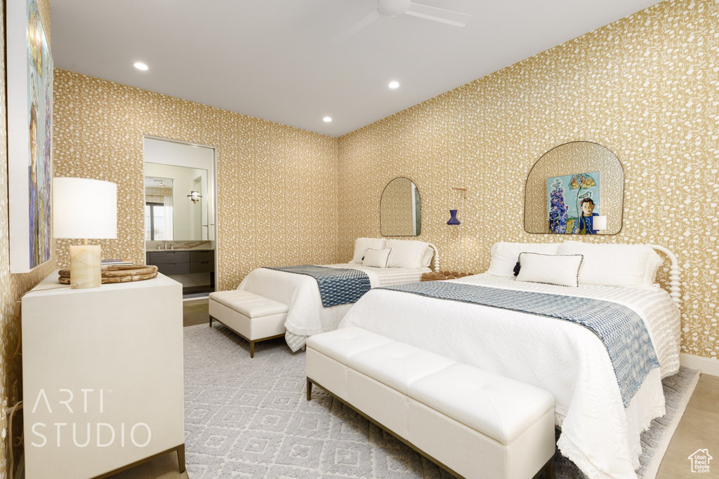 Bedroom with ensuite bath, ceiling fan, and light colored carpet