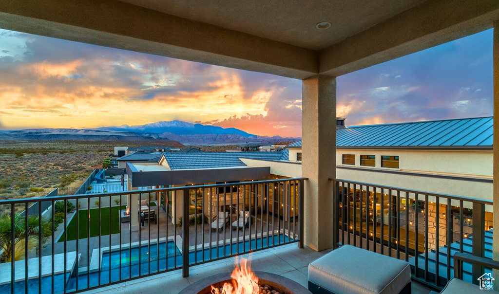 Balcony at dusk featuring a fire pit and a mountain view