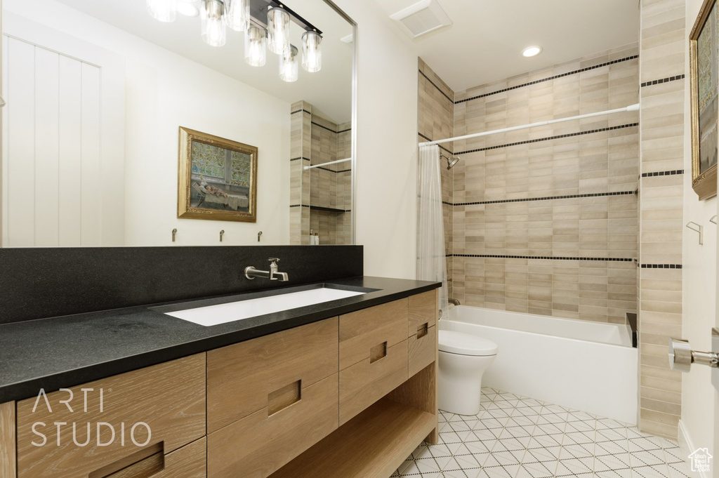 Full bathroom with shower / bath combo with shower curtain, vanity, tile patterned floors, and toilet