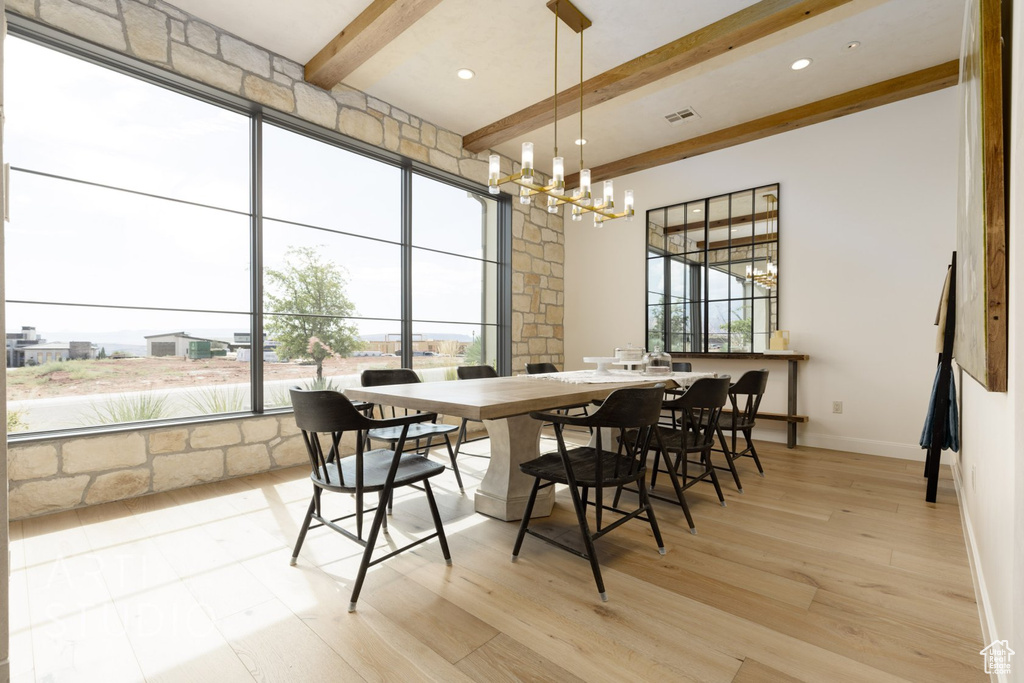 Dining room with beamed ceiling, light hardwood / wood-style floors, and a notable chandelier