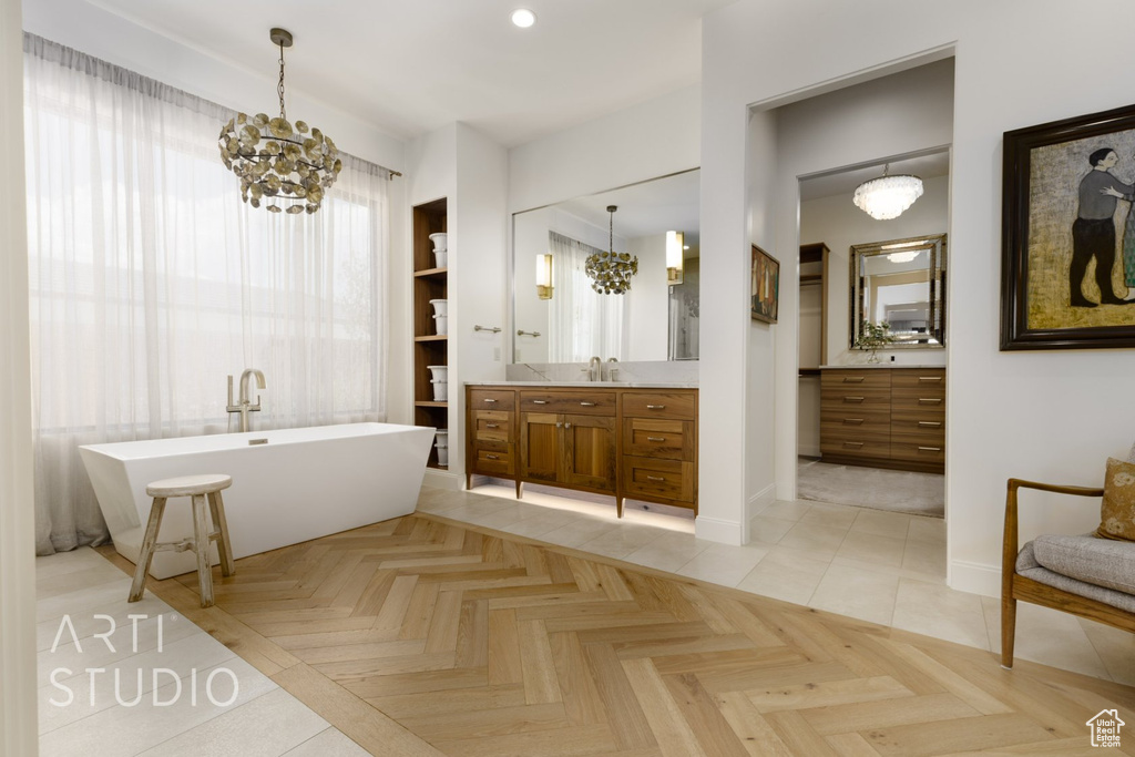 Bathroom featuring a notable chandelier, parquet flooring, vanity, and a bathtub