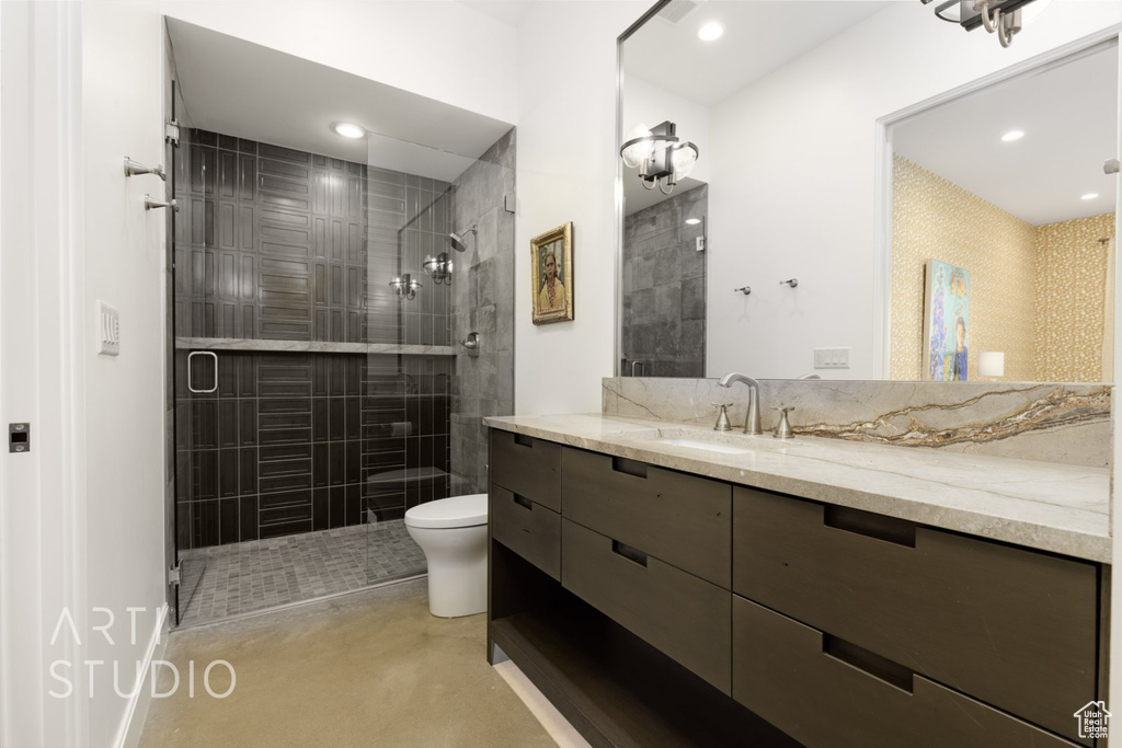 Bathroom featuring vanity, toilet, and an enclosed shower