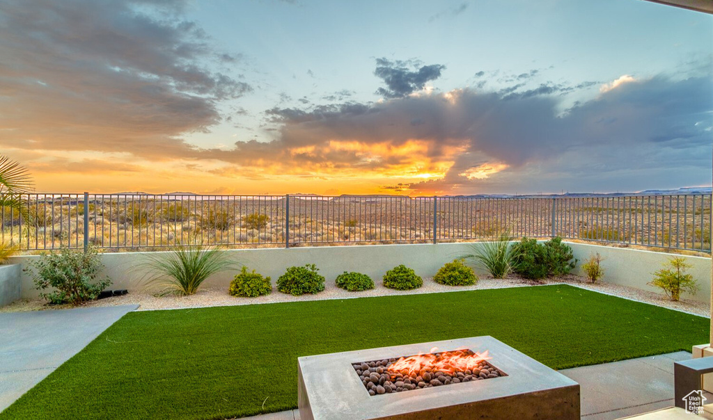 Yard at dusk featuring an outdoor fire pit