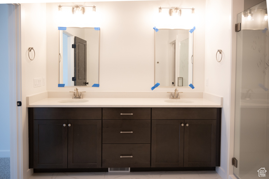 Bathroom featuring dual bowl vanity and tile patterned flooring