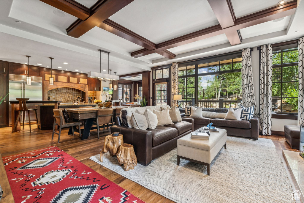 Living room with a fireplace, beamed ceiling, hardwood / wood-style floors, and coffered ceiling