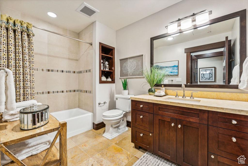 Full bathroom featuring vanity, toilet, tiled shower / bath, and tile patterned flooring