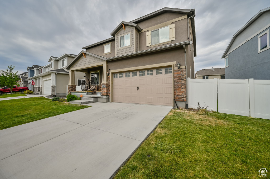 Craftsman house with a garage and a front yard