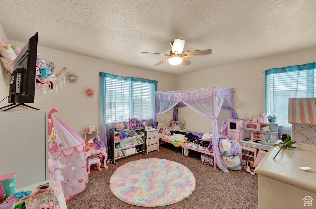 Bedroom featuring multiple windows, carpet, a textured ceiling, and ceiling fan