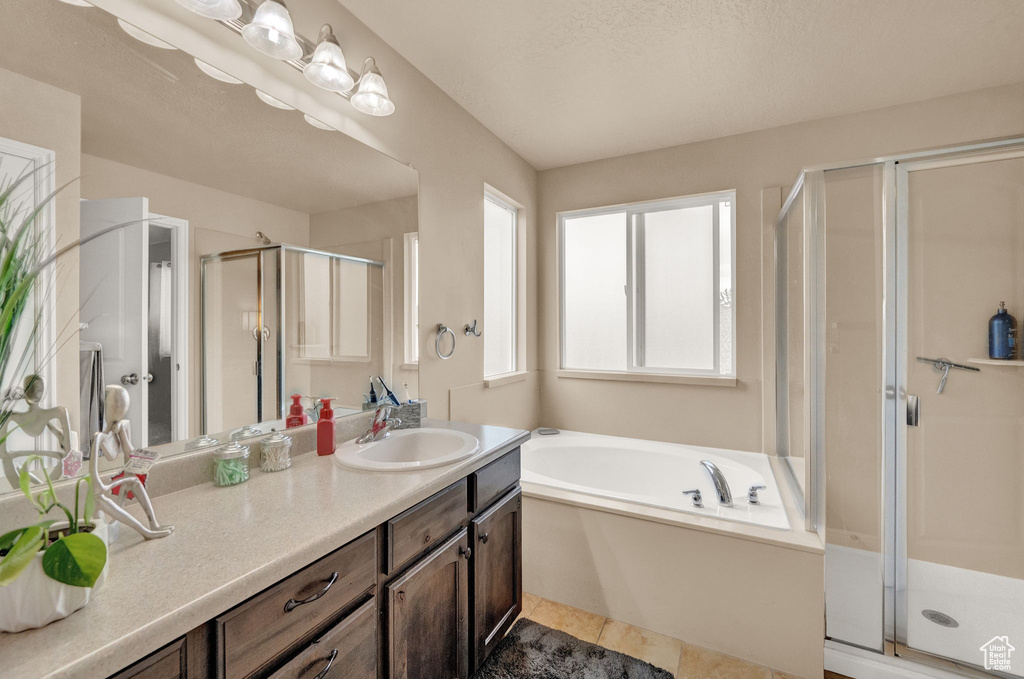 Bathroom featuring vanity, tile patterned flooring, and independent shower and bath