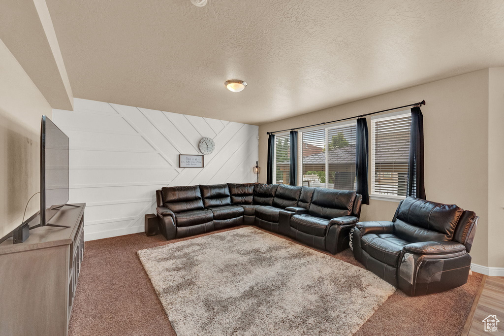 Living room with a textured ceiling and hardwood / wood-style floors