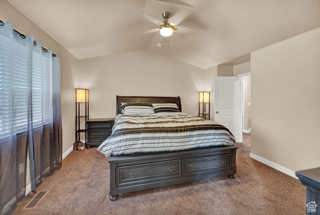 Carpeted bedroom featuring lofted ceiling and ceiling fan