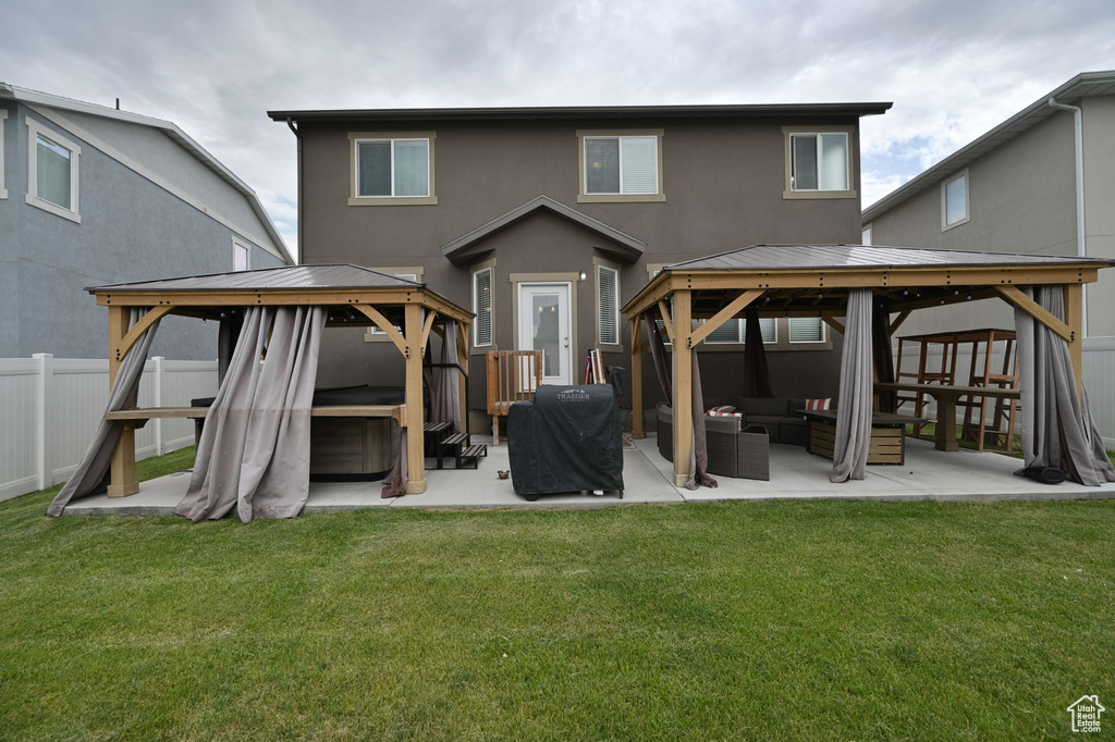 Back of property featuring a yard, a gazebo, an outdoor hangout area, and a patio area