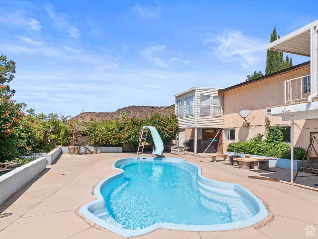 View of swimming pool with a patio and a water slide