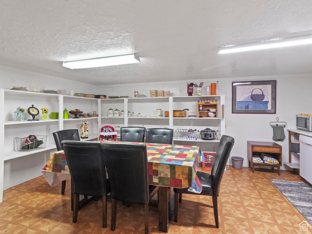 Dining room featuring light parquet floors and a textured ceiling