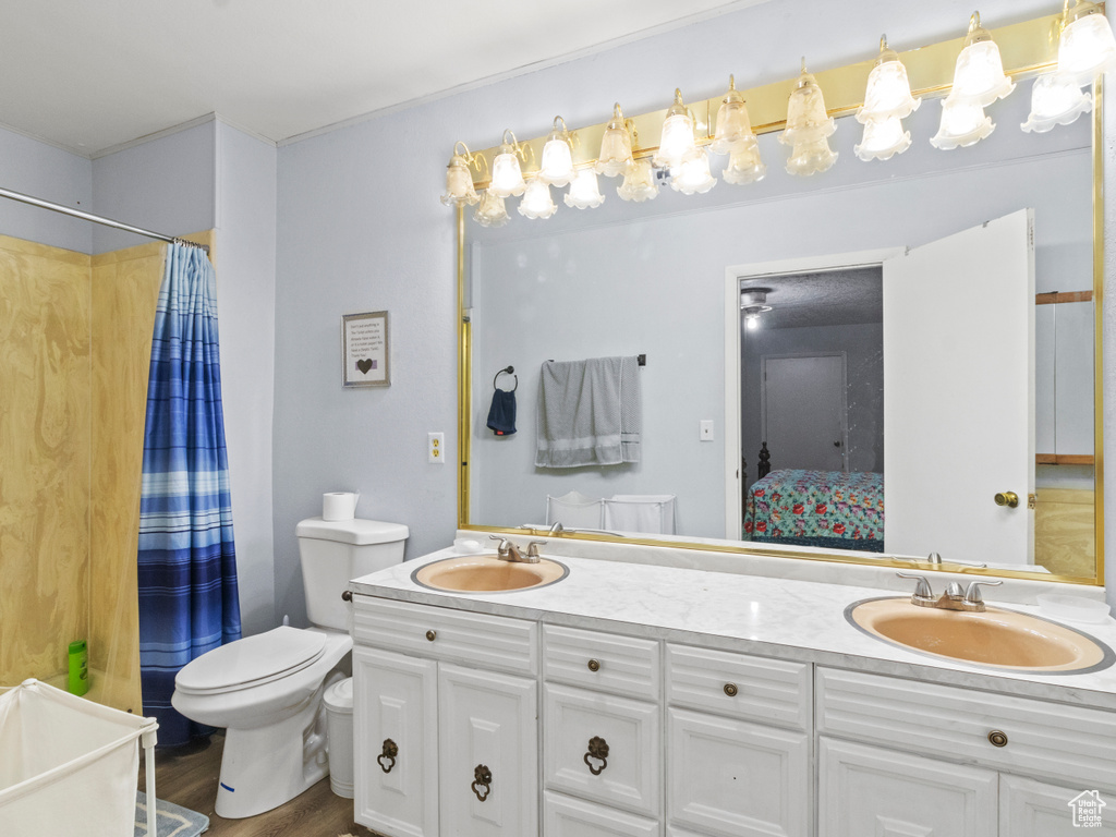 Bathroom featuring hardwood / wood-style floors, toilet, and double sink vanity