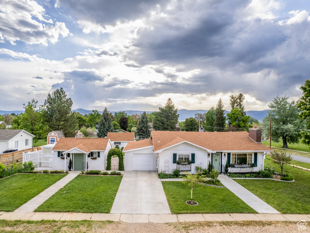 Ranch-style home featuring a garage and a front lawn