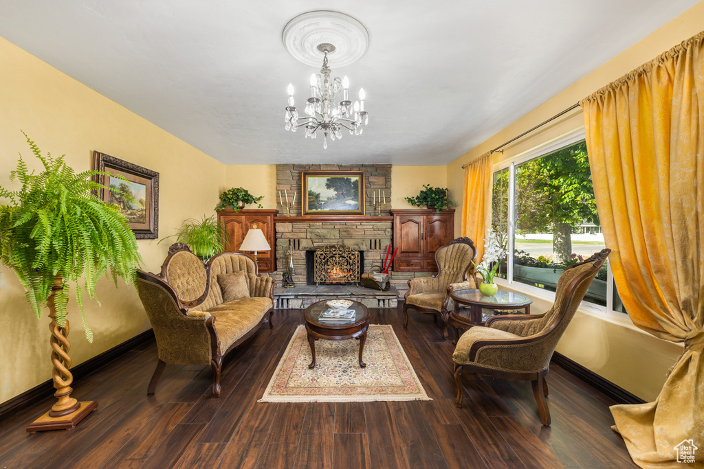 Living room featuring a stone fireplace, a chandelier, and hardwood / wood-style flooring