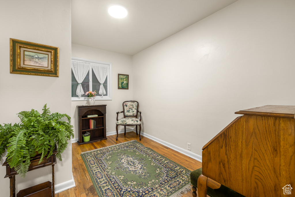 Sitting room with vaulted ceiling and hardwood / wood-style floors