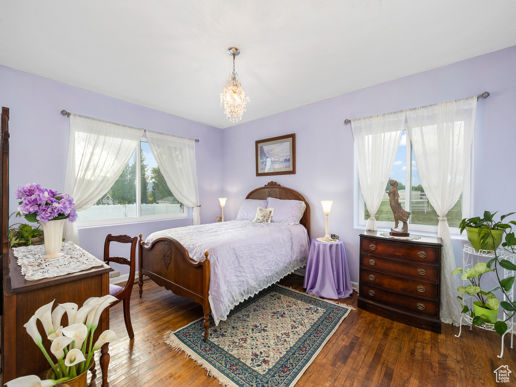 Bedroom with a notable chandelier and wood-type flooring