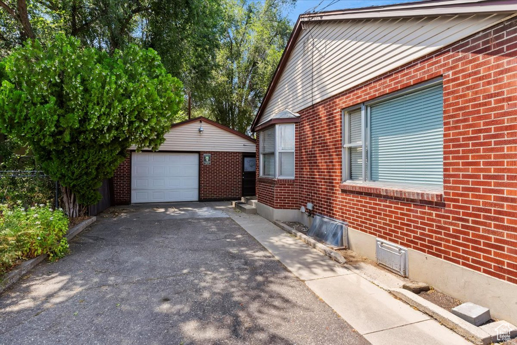 View of side of property with a garage and an outbuilding