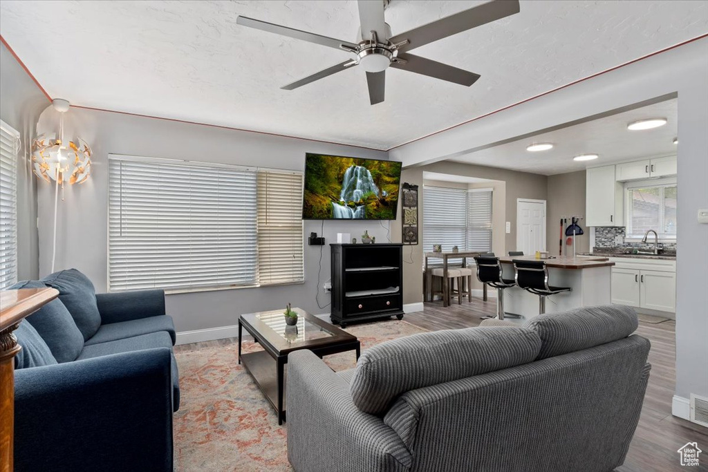 Living room with sink, light wood-type flooring, and ceiling fan