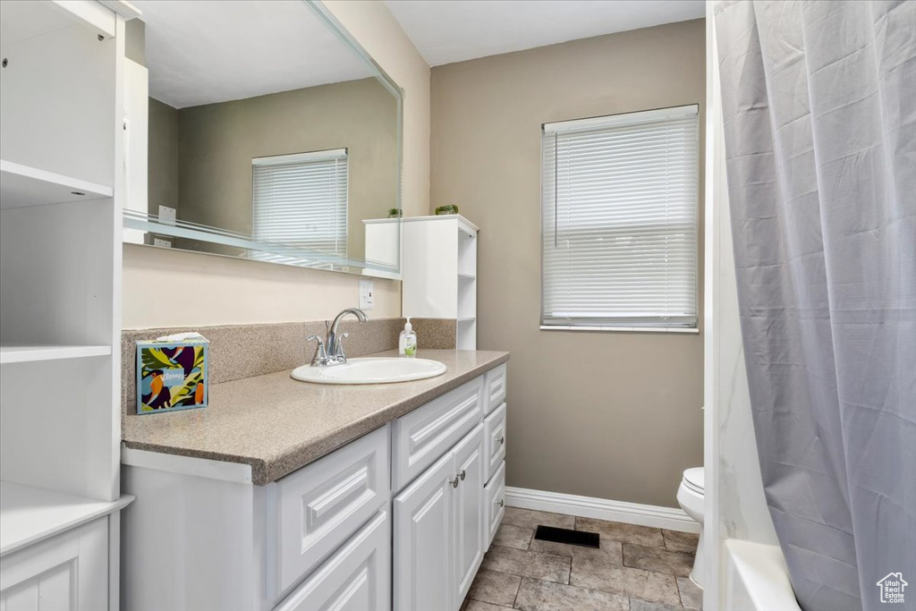 Bathroom featuring vanity, tile patterned flooring, and toilet