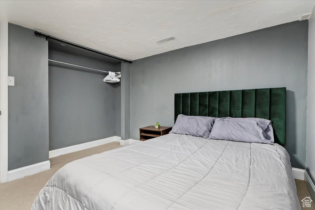 Carpeted bedroom featuring a closet