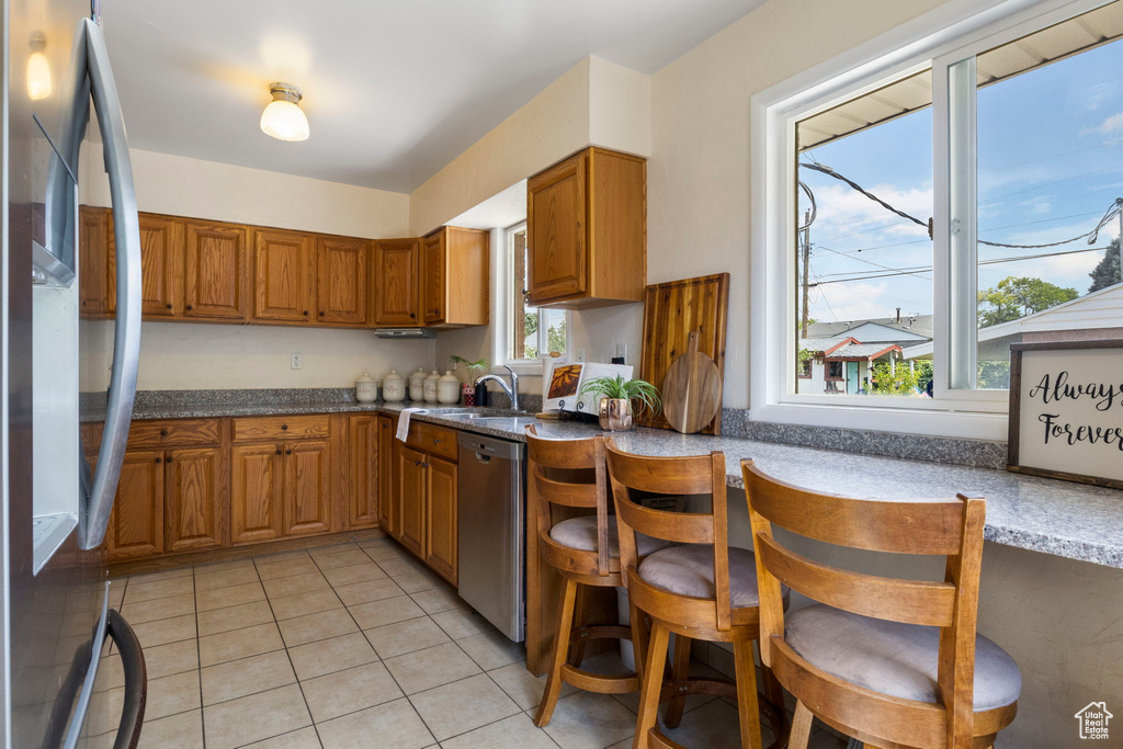 Kitchen featuring appliances with stainless steel finishes, light tile patterned floors, and sink