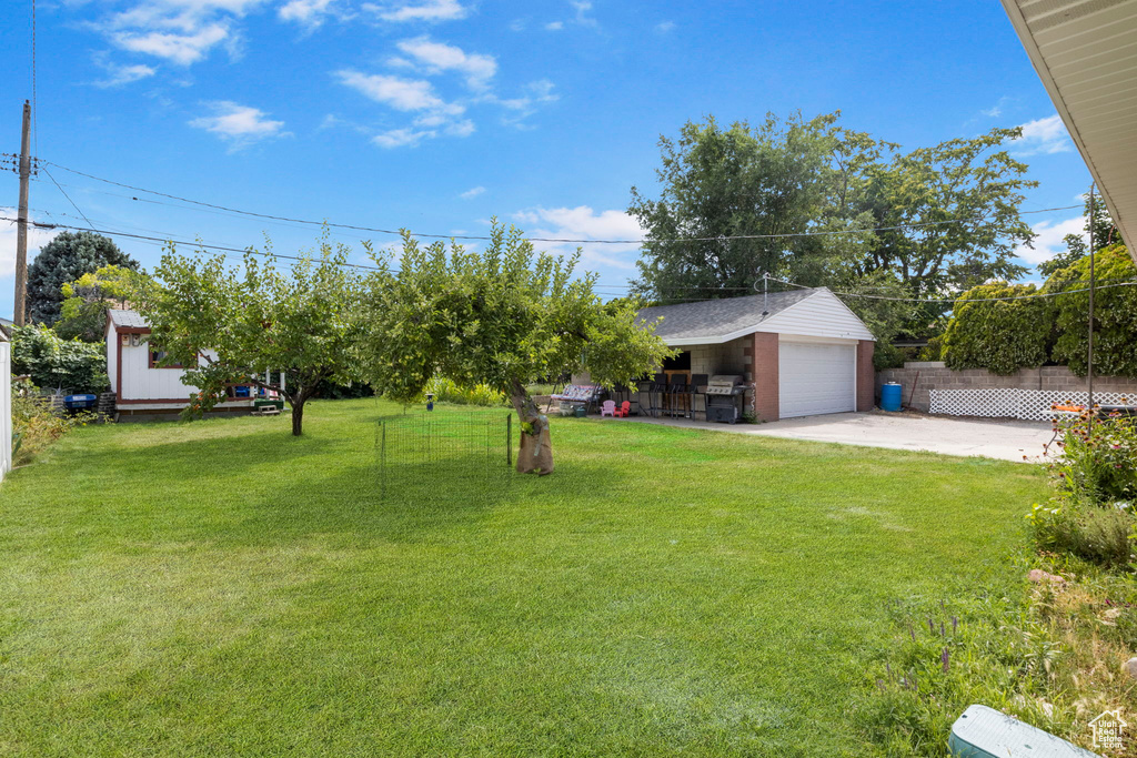 View of yard featuring a garage and an outdoor structure